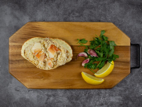 Dressed crab on a board with lemon, garlic and parsley
