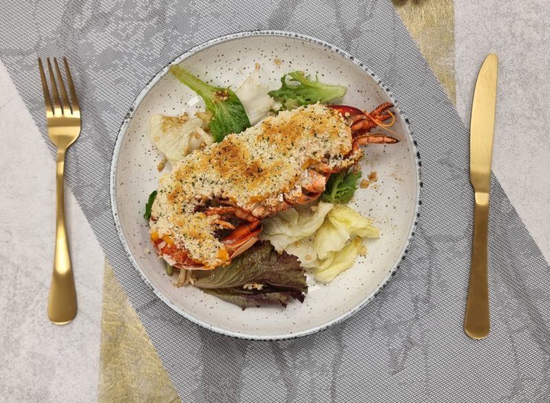 Lobster thermidor served on plate with cutlery