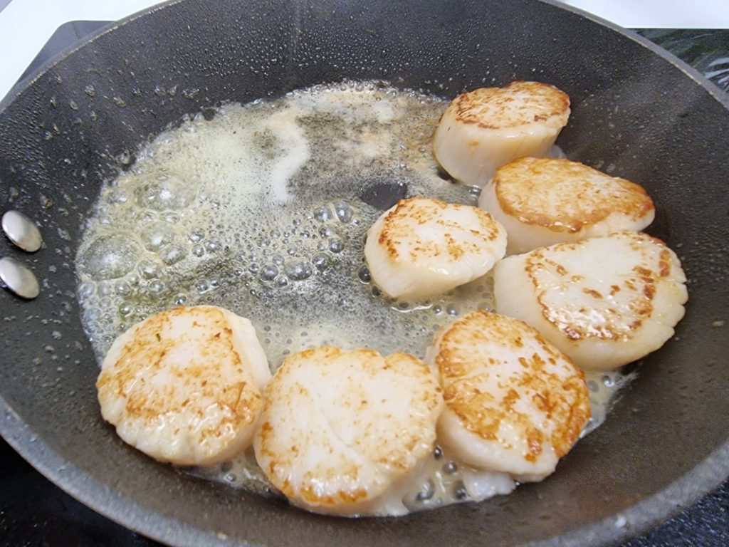 Scallops frying in a pan