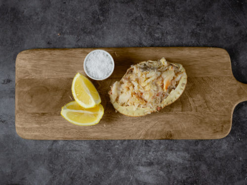 Dressed Crab on a wooden board with lemon and salt