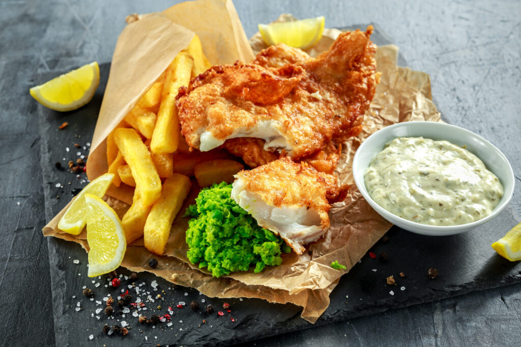 fish and chips with mushy peas and tar tar sauce on slate